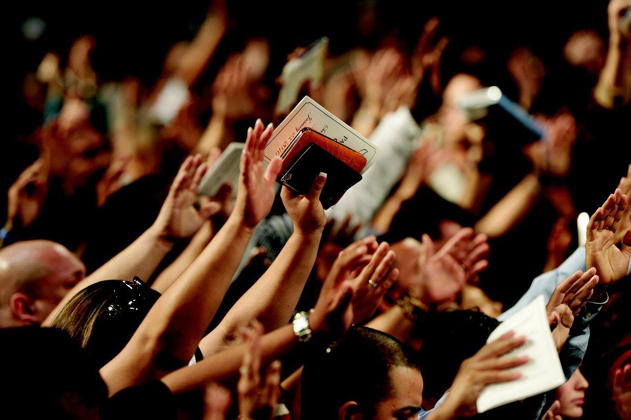 A crowd of people with hands raised in the air.