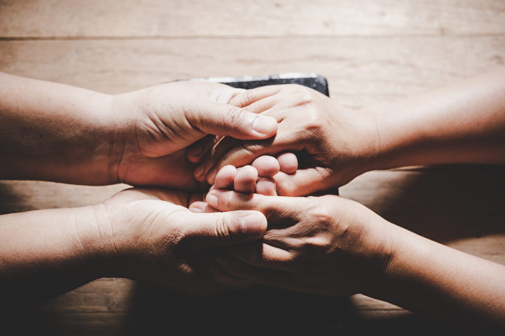 A group of people holding hands in the middle.