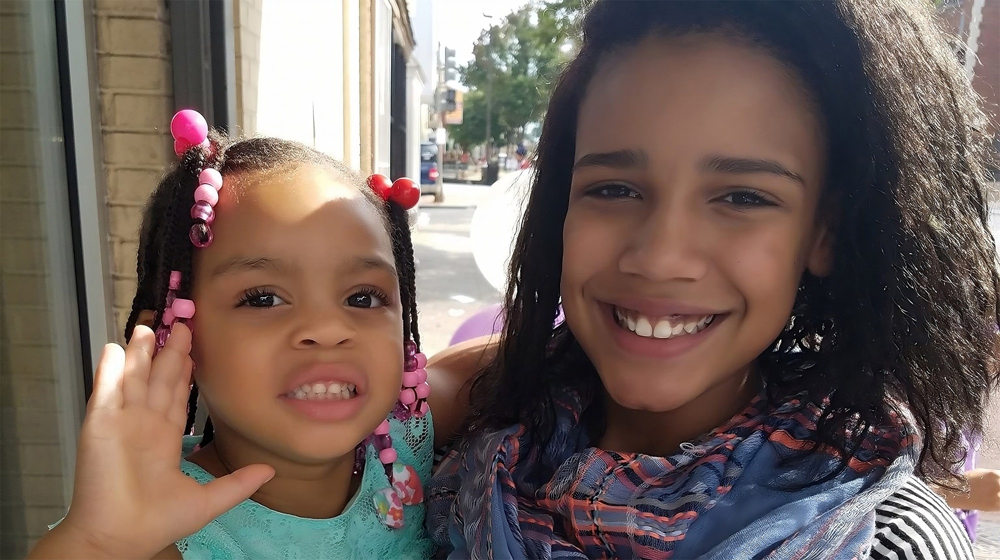 Woman holding a young girl and smiling to the camera