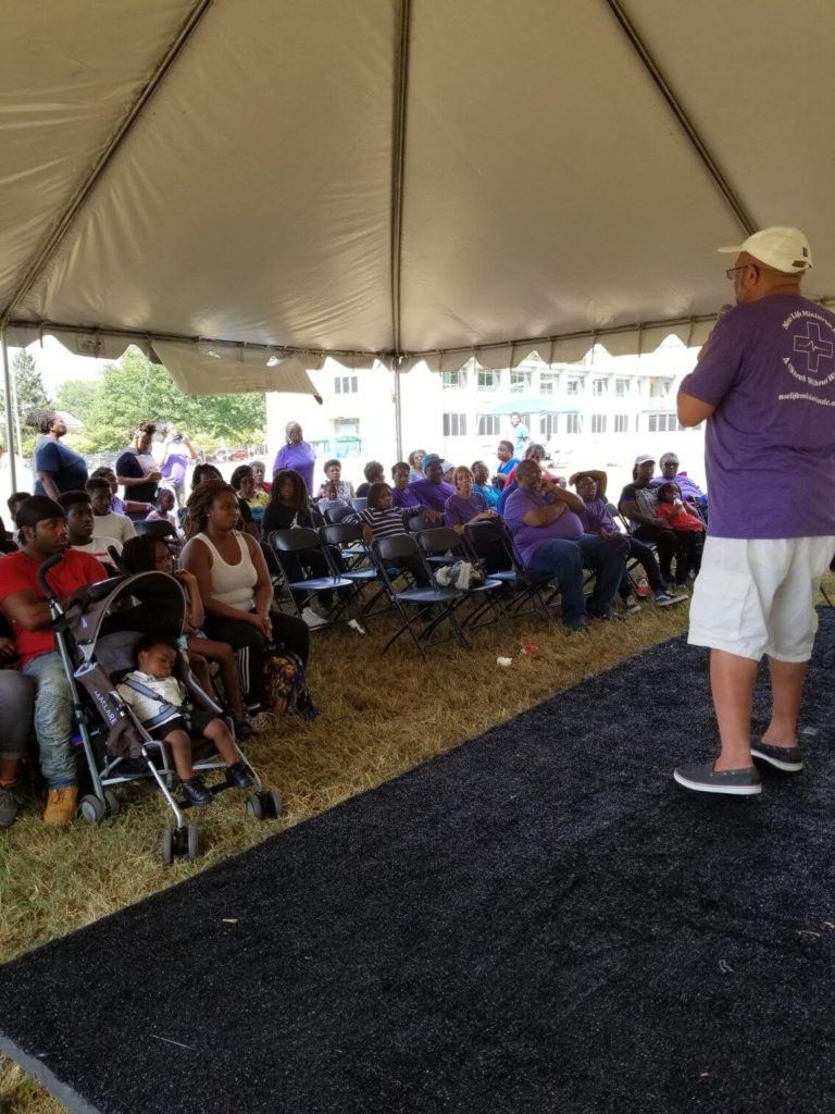 Rev. Ernest Lyles, Sr. speaking in front of many people